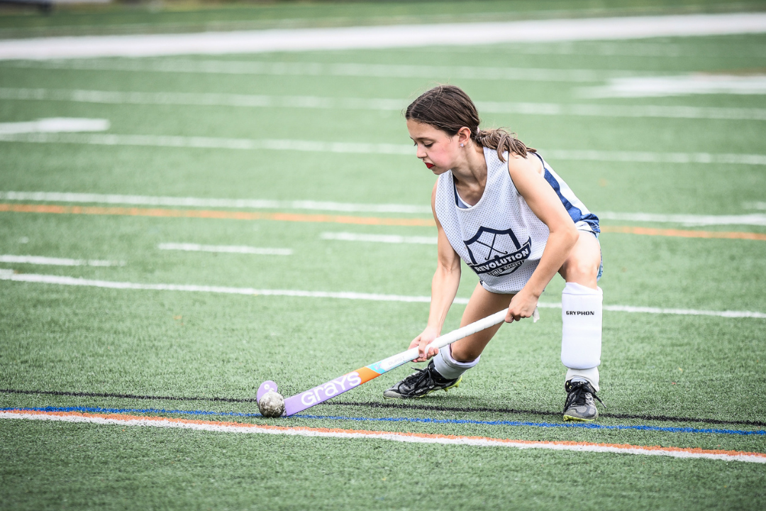 Girl Pushing Hockey Ball with Grays Stick